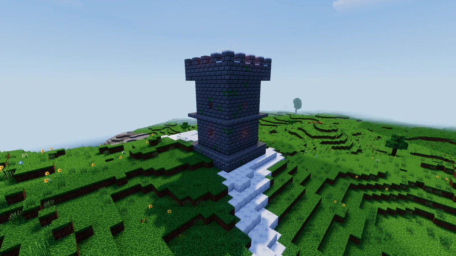 A stone tower with a fire burning on its top on a mountain summit